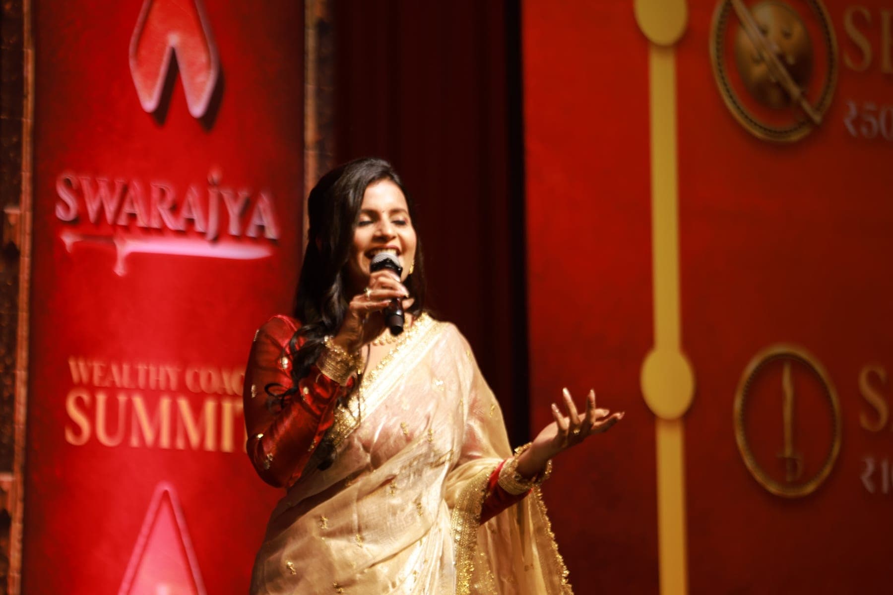 Tripti speaking with a microphone