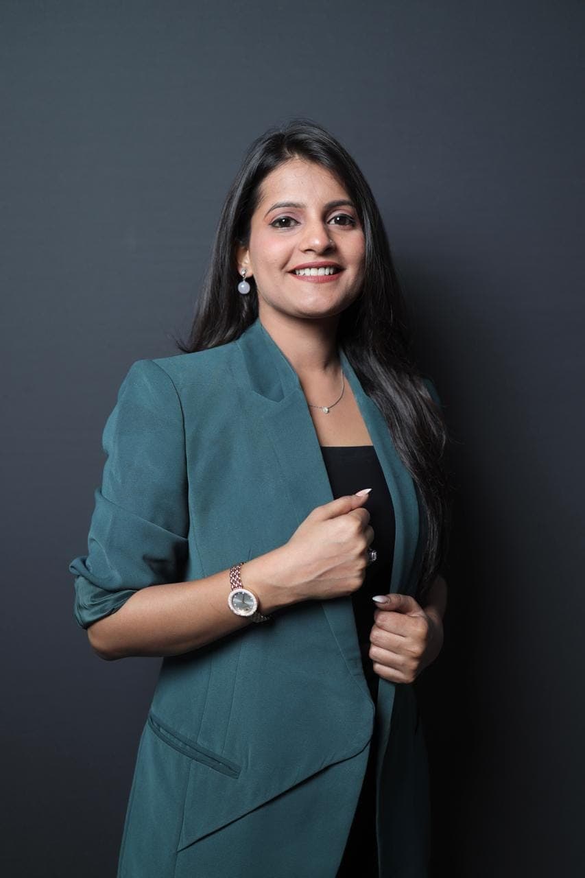 Tripti Sharma, psychologist in Noida, smiling in a teal blazer